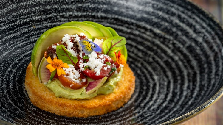 The avocado toast served at Epcot's International Festival of the Arts sits on a plate. 