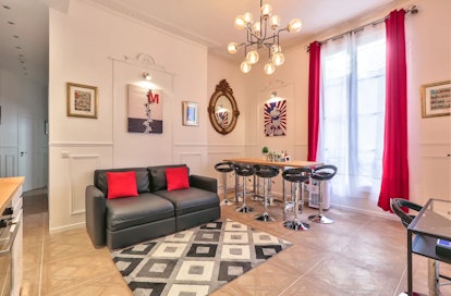 This Mickey Mouse-themed Airbnb in Paris has a leather couch, a big window, and Mickey decor through...