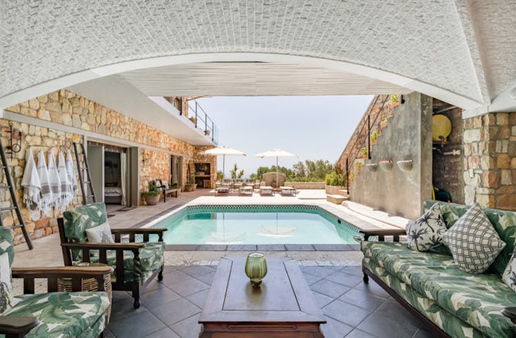 A beautiful villa in Cape Town, South Africa has a pool and palm-tree inspired furniture.
