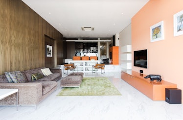 The living room of a luxe apartment in Cape Town, South Africa has a peach wall and bold style.