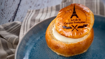 Brie in a homemade bread bowl served at Epcot's International Festival of the Arts sits on a plate. 