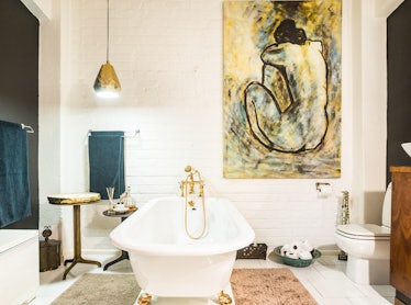 An artsy loft in Cape Town, South Africa has a luxurious bathtub and large paintings on the walls.