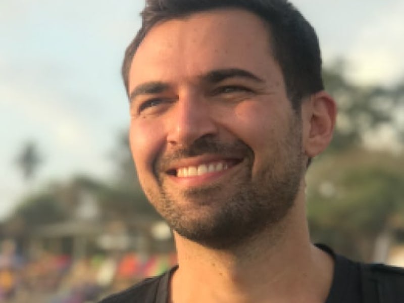 A closeup of Michael Alexis smiling and looking into the distance