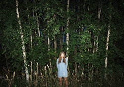 Woman standing alone in woods