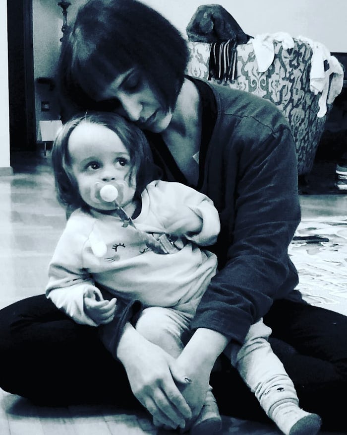 A mother sits on floor with her toddler