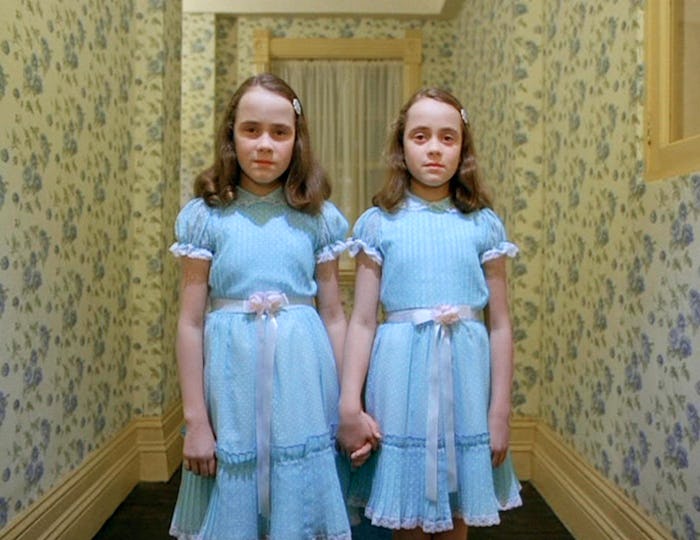 The twins in the shining stand in blue dresses in the hallway