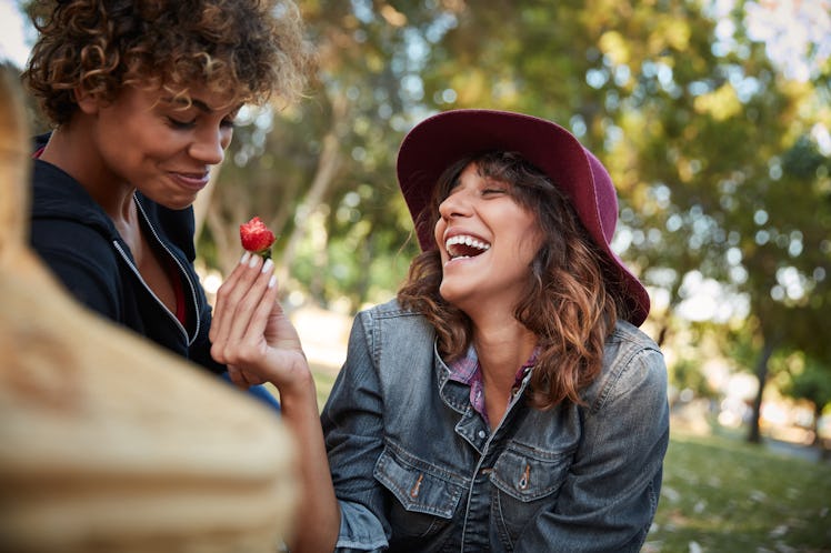 Girlfriends having strawberry on picnic