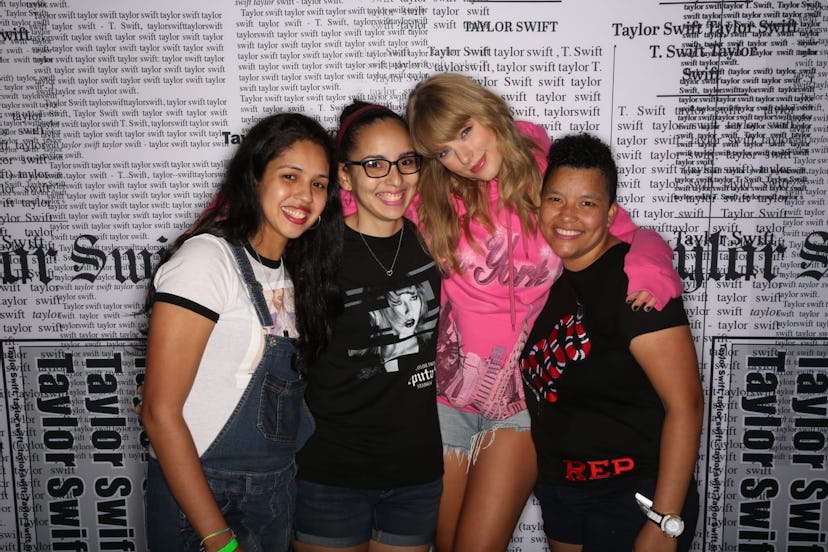 Three women pose with Taylor Swift