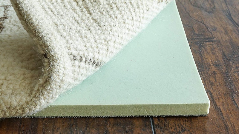 The best rug pads for soundproofing (like the memory foam one shown under a rug in this photo) are t...
