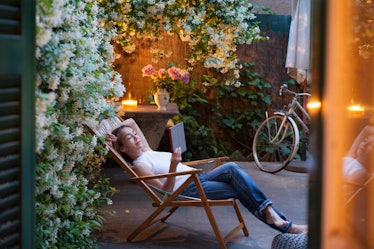 A woman reading a book while sitting in a garden