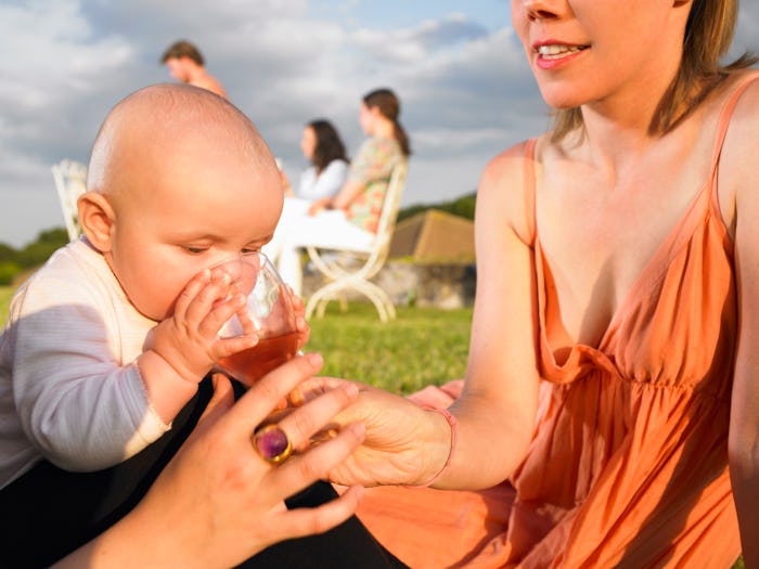 A mother in Agen, France, allows her baby to sniff her wine glass
