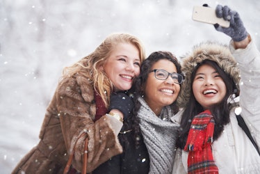 Three young female friends happy in snow, winter