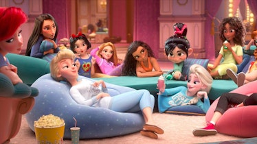 A big group of Disney princesses hangs out in a living room in their PJs in a scene from 'Ralph Brea...