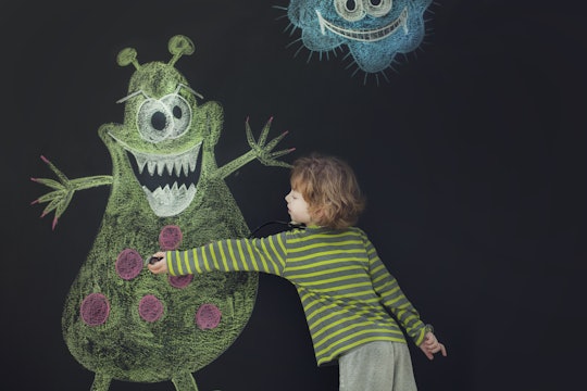 boy drawing monster on chalkboard