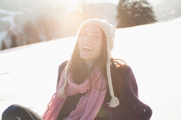 Young woman laughing in the sunlight & snow