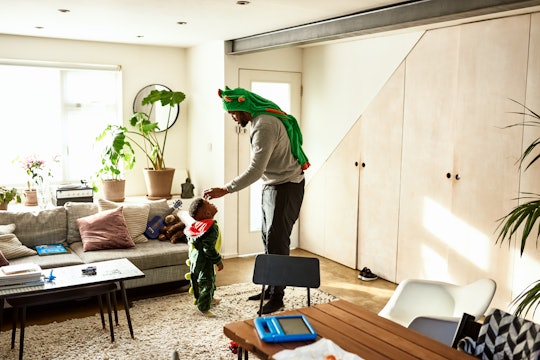 Dad in dinosaur plays with son in dinosaur costume