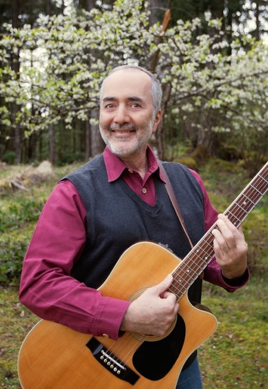 Raffi stands outside with guitar