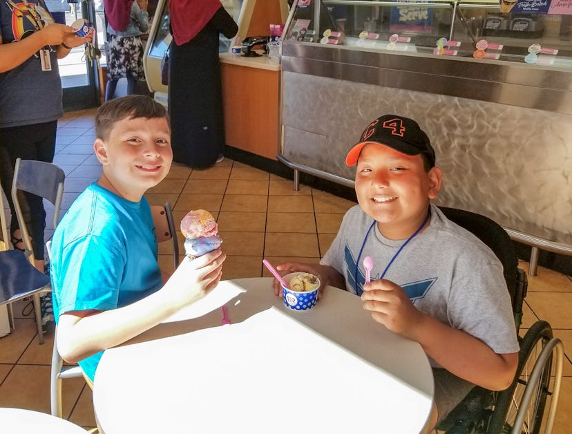 A picture of two boys smiling around a table.