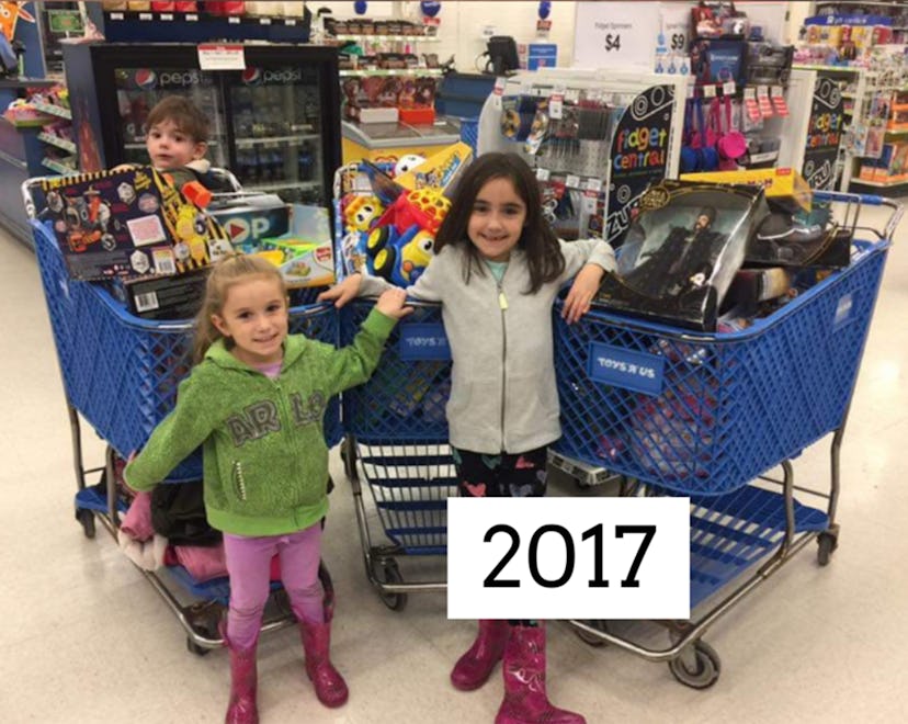 A picture of two girls in front of full carts of toys.