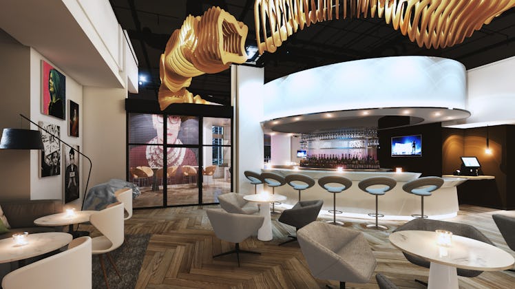 The interior of Hotel Zena features intimate lighting, trendy furniture, and a mural of Ruth Bader G...