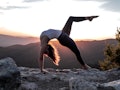 Young woman stretching at sunrise