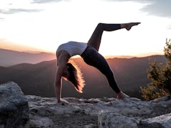 Young woman stretching at sunrise