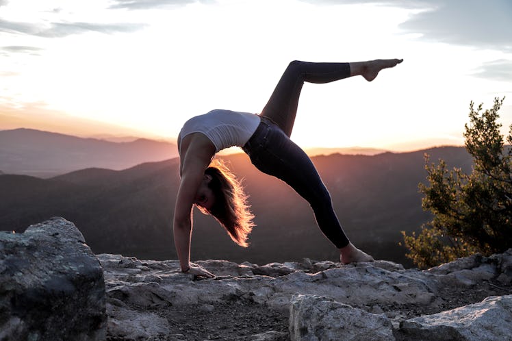 Young woman stretching at sunrise