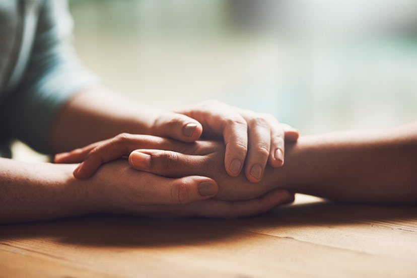 couple holding hands on a wooden table