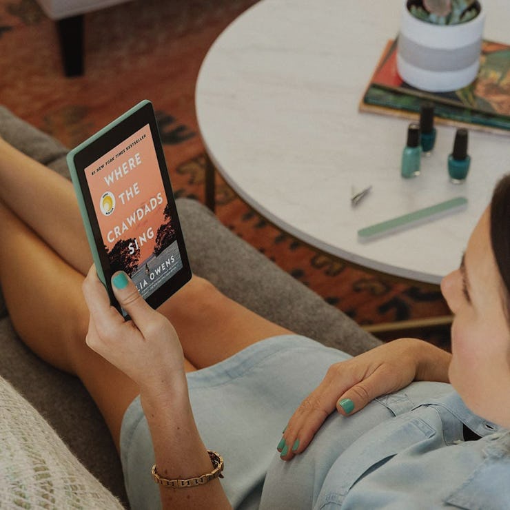 A woman on a couch using her 7-inch tablet