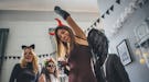 Young woman partying in devil's costume on Halloween before posting on Instagram with a clever capti...