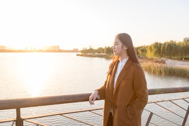 Young woman standing on a bridge in fall