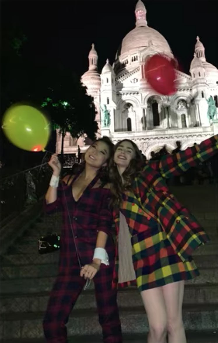 Emily (Lily Collins) and Mindy (Ashley Park) pose with balloons in their hands. 