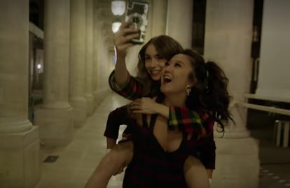 Emily (Lily Collins) gets a piggyback ride from Mindy (Ashley Park), and snaps a selfie. 