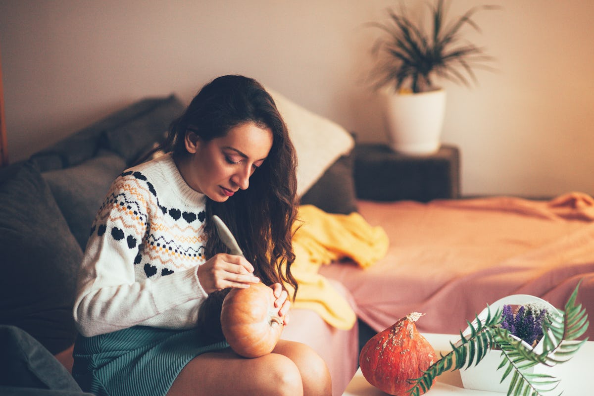 Young woman carving pumpkin