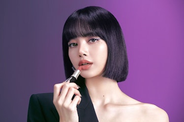 Lisa from BLACKPINK in MAC campaign photo applying lipstick.