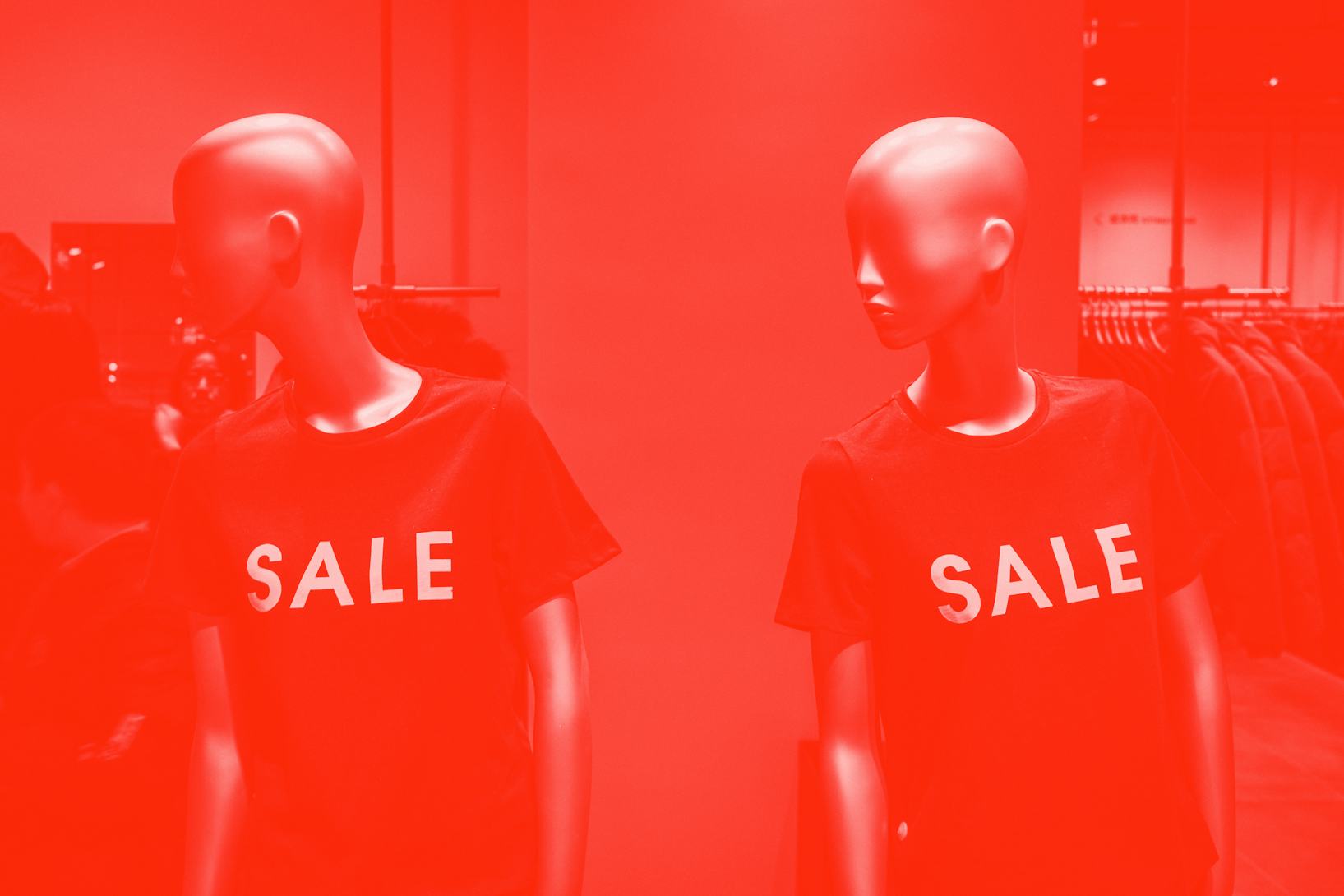 Two mannequins are positioned side by side, wearing T-shirts that read "SALE."