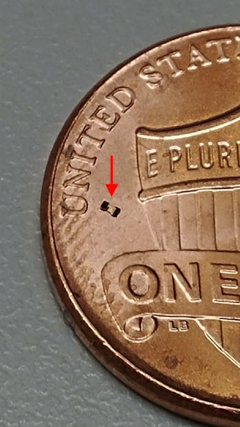 A microrobot next to the "U" of the United States on a penny's tails side