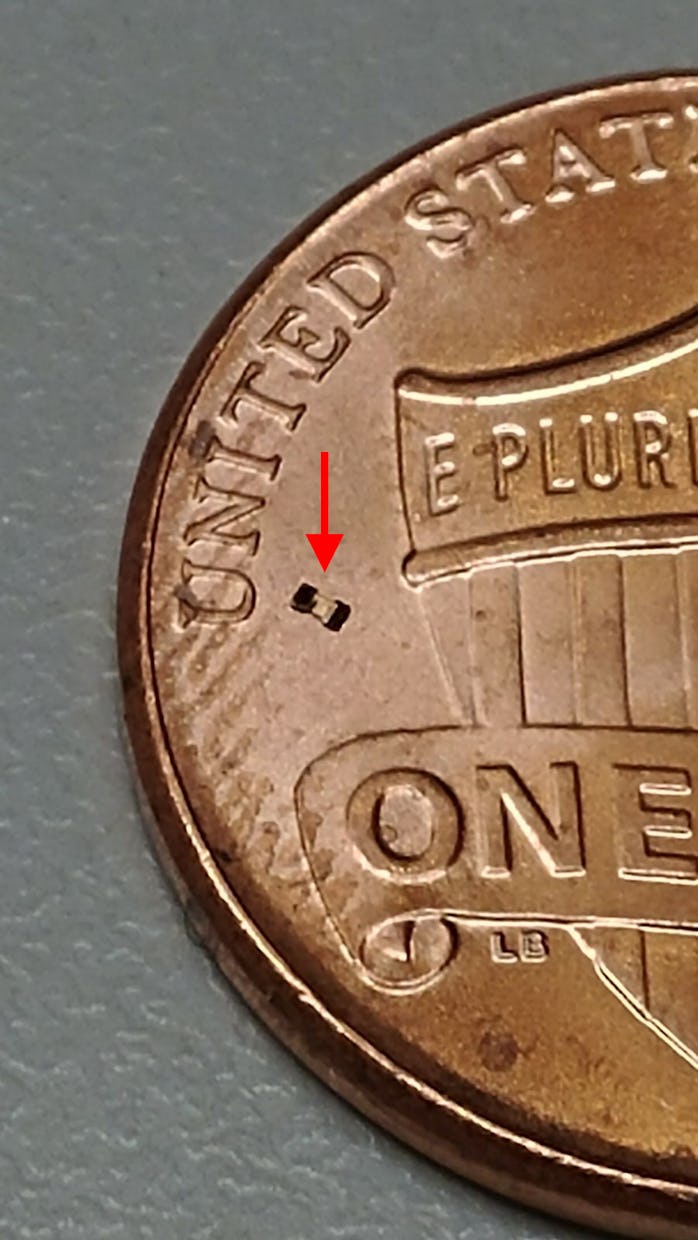 A microrobot next to the "U" of the United States on a penny's tails side