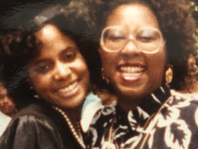 Two women posing and smiling while wearing pearl earrings