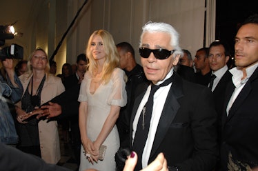 Karl Largerfeld in black sunglasses and a black suit at a red carpet event