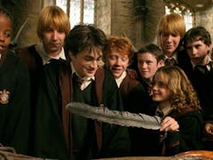 Harry Potter and his friends look at a gift with a feather in it from 'Harry Potter and the Prisoner...