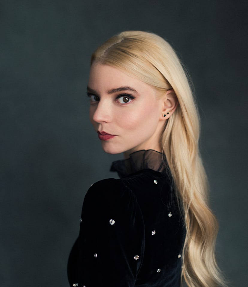 Anya Taylor-Joy in a black velvet sequin shirt, looking over her shoulder