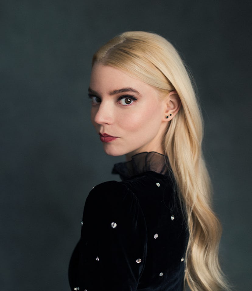 Anya Taylor-Joy in a black velvet sequin shirt, looking over her shoulder 