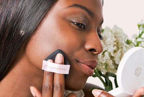 Model applying EM Cosmetics' new Daydream Cushion with puff applicator.