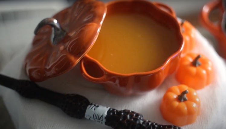 A pumpkin filled with a 'Harry Potter'-inspired drink sits on the table next to a 'Harry Potter' wan...