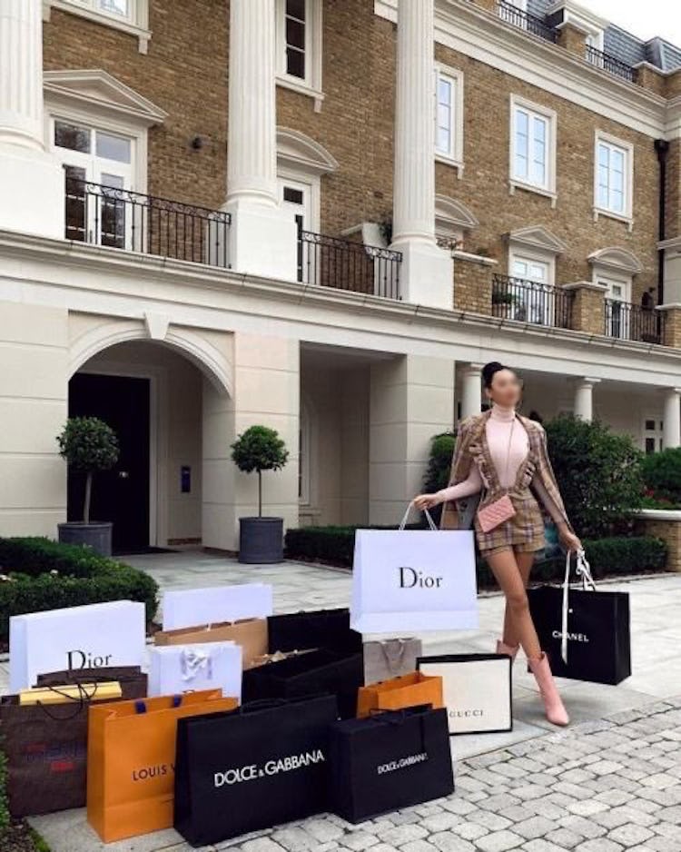 A photo of a woman outdoors with more shopping bags than she can carry.