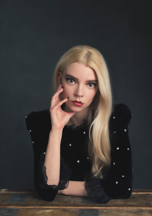 Anya Taylor-Joy in a black velvet sequin shirt, with her face leaning against her hand 