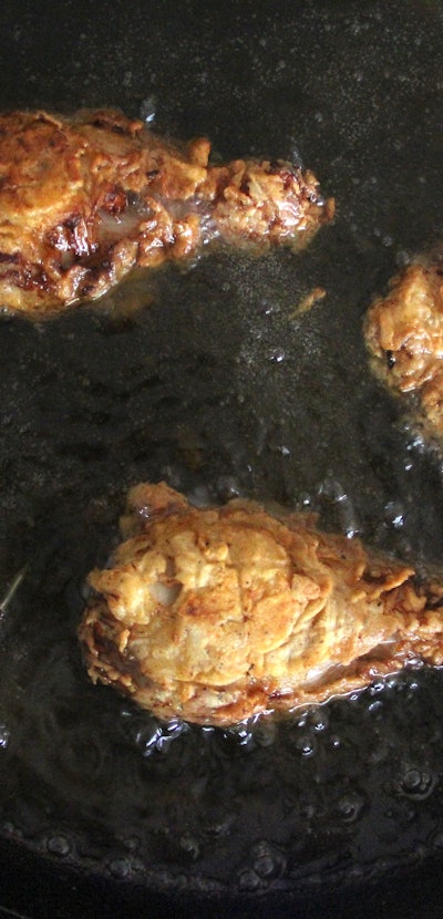 Crunchy fried chicken in hot oil while being fried