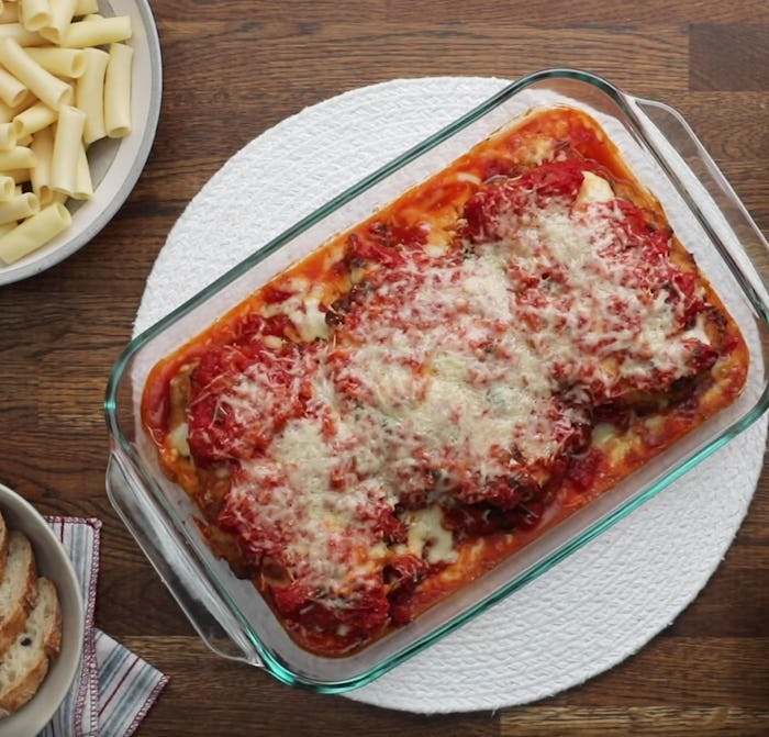 Dr. Jill Biden's chicken parm in baking dish, on a table with bread and pasta noodles to the side
