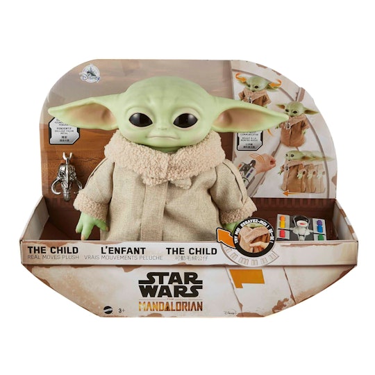 An image of a Baby Yoda plush in a box with a pendant and remote control.